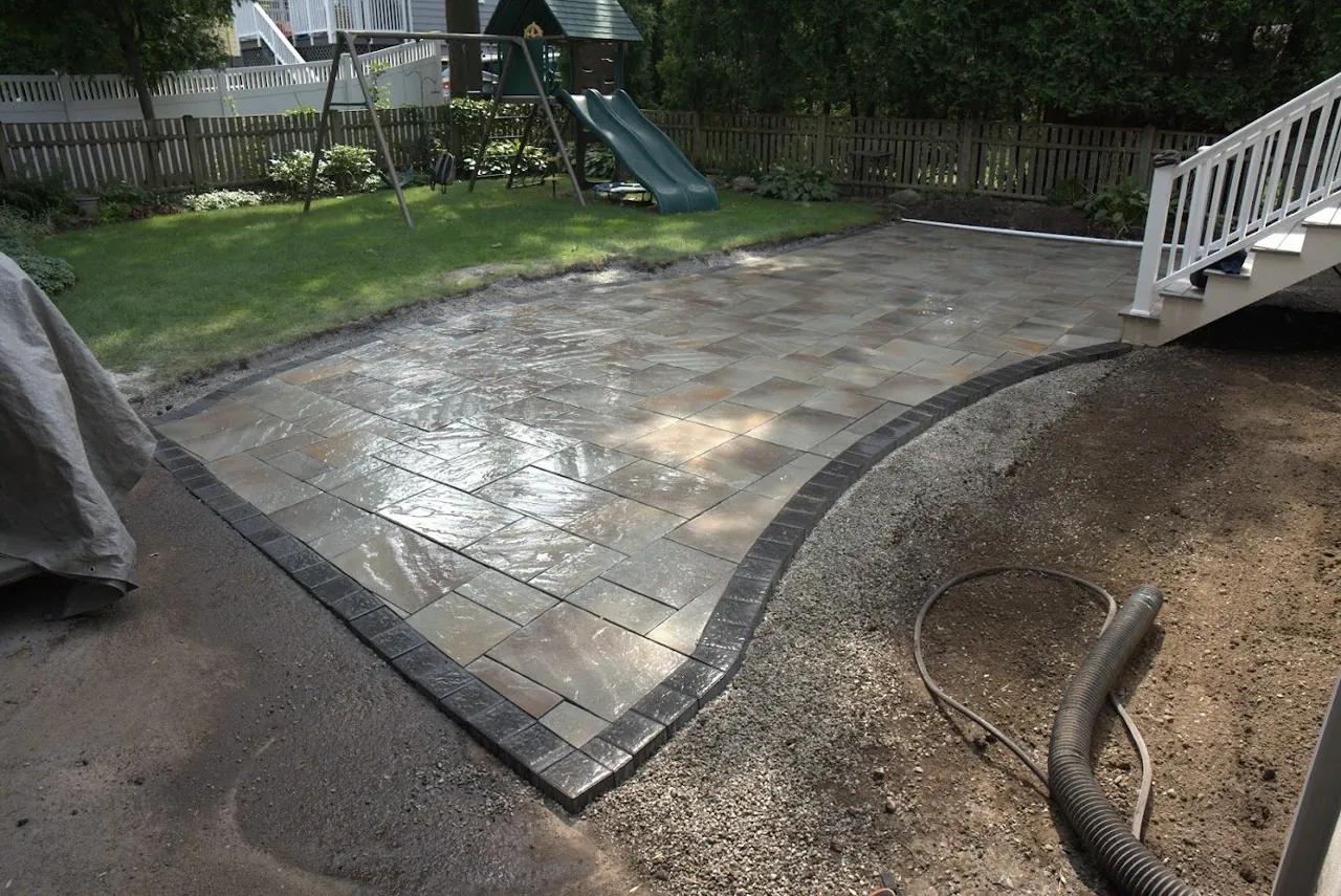 Finished bluestone paver patio with charcoal border in a Greater Boston backyard by American Elm Landscape