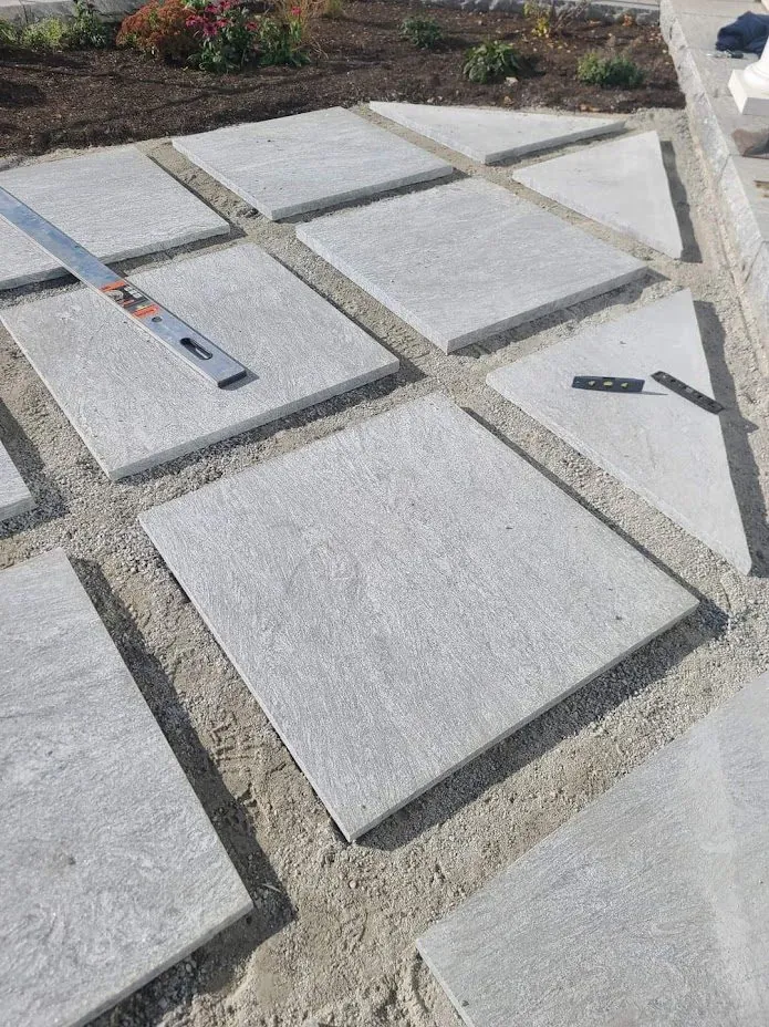 Large-format paver patio being installed and leveled by American Elm Landscape, Boston area